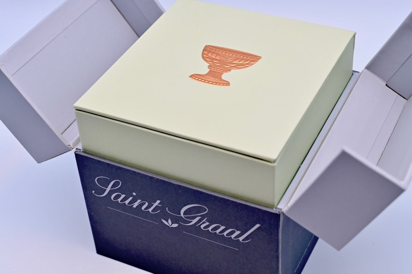 The Saint Graal box, its pale lid bearing the copper chalice, in the shipper it arrives in
